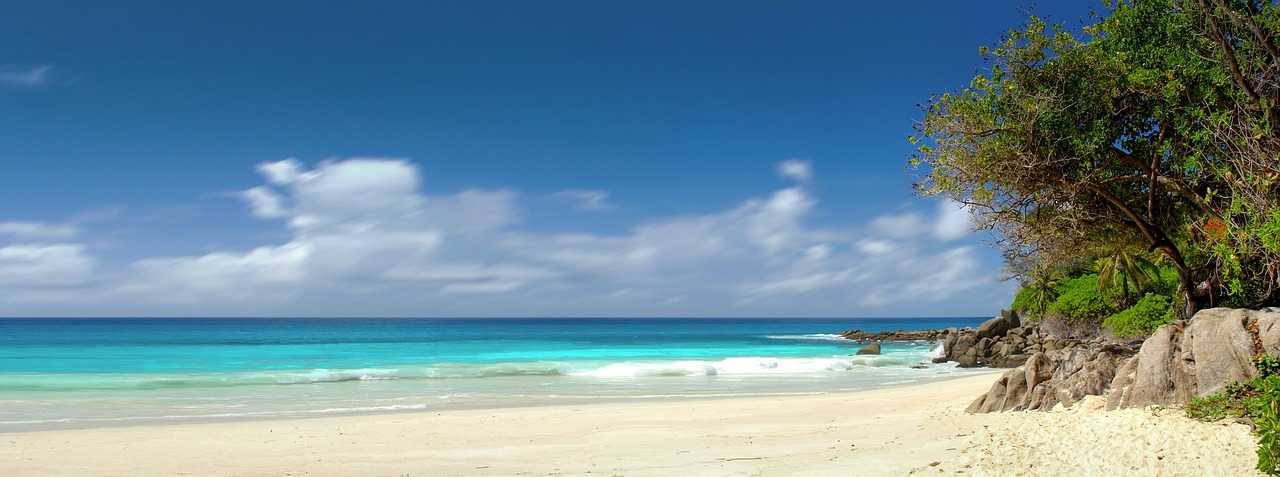 A picture of a private beach. Yu can see the tropical turquoise of the water, and the clouds in the distance. Reminds us that nature has the best essentials!