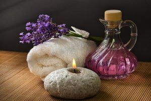 Oil in a jar with a towel, and a candle is burning - for massage, or wellness.